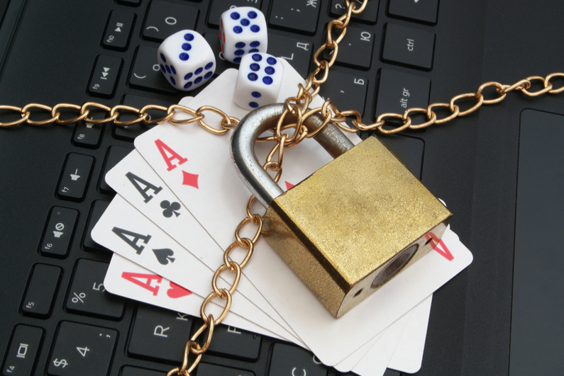 Cards, dice, and laptop keyboard with padlock