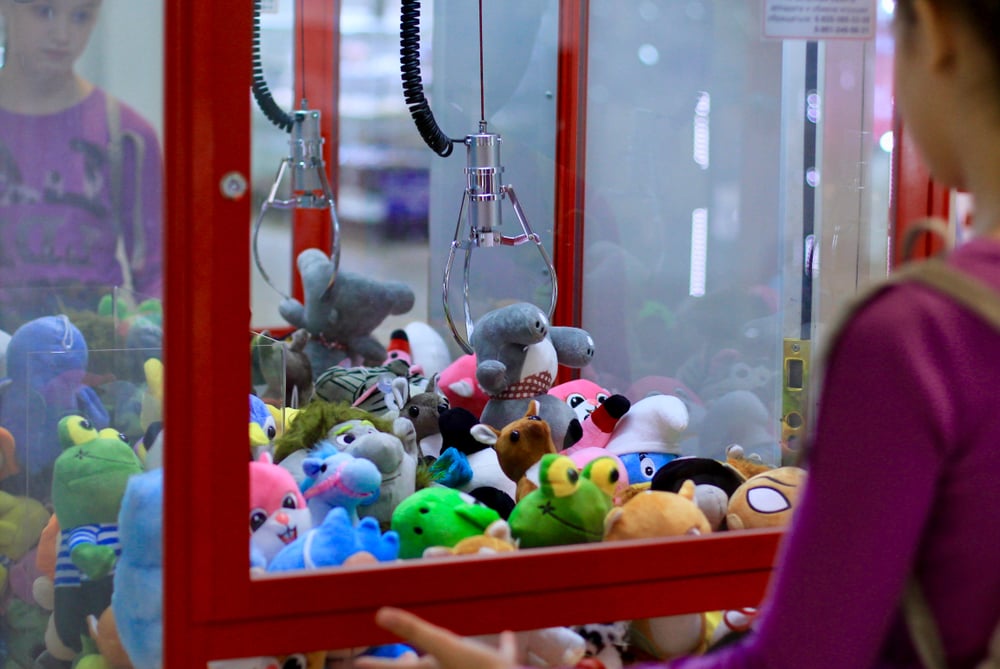 girl playing at claw machine